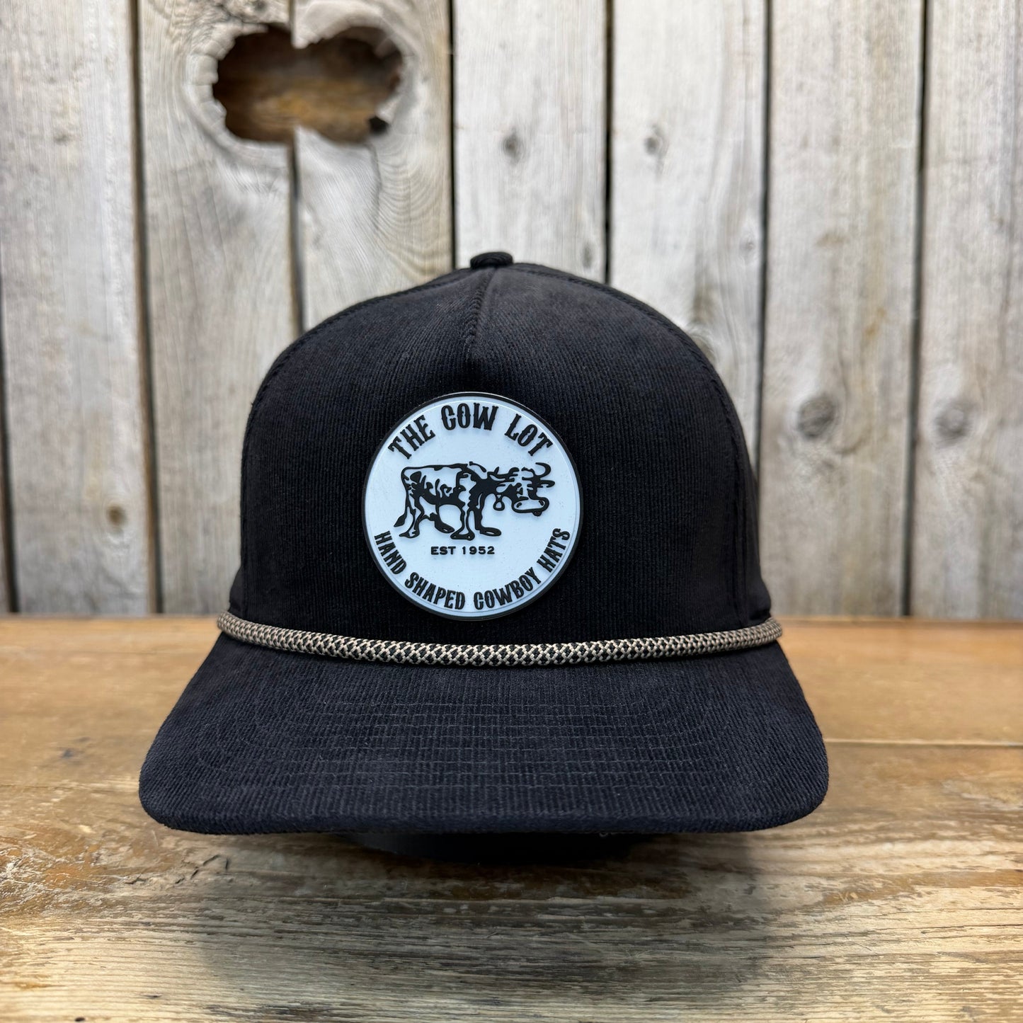 Black cap with a logo on a wooden surface