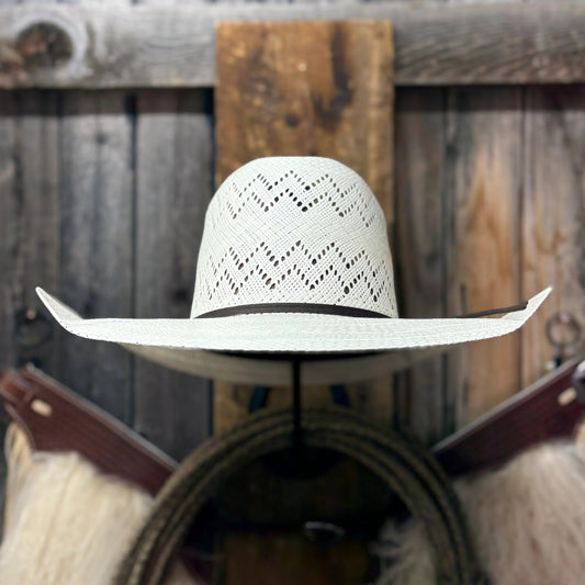 White cowboy hat on a wooden wall with rustic background