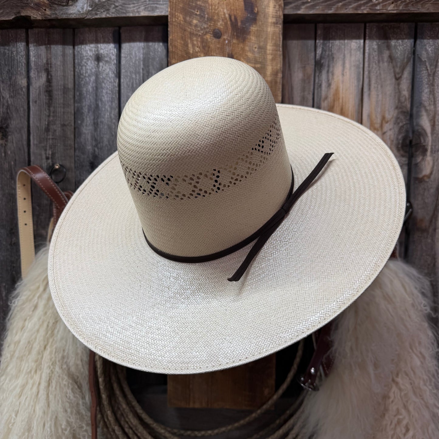 Beige straw hat with a black band on a wooden background