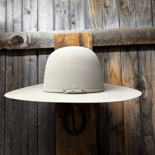 Wide-brimmed hat with a strap against a wooden background