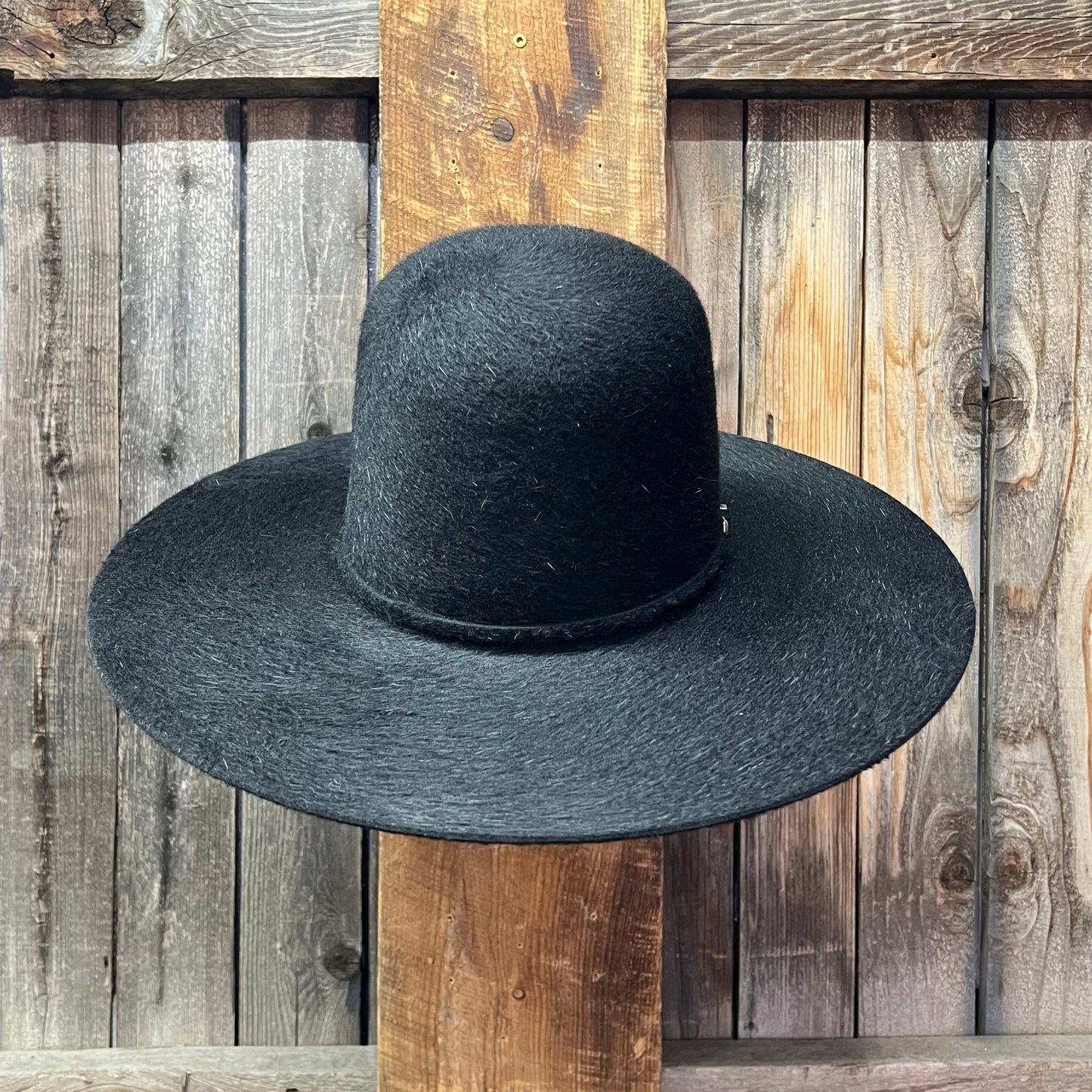 grizzly Black hat on rack wooden background