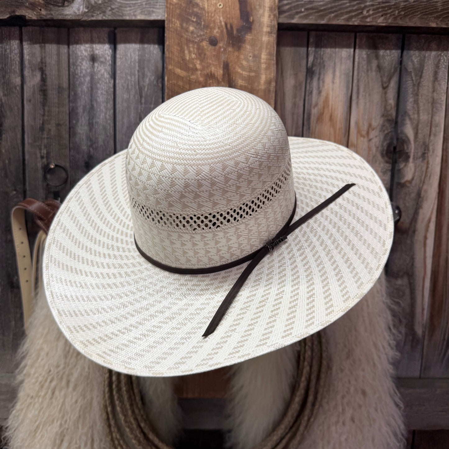 Beige straw hat with a black band on a mannequin against a wooden background