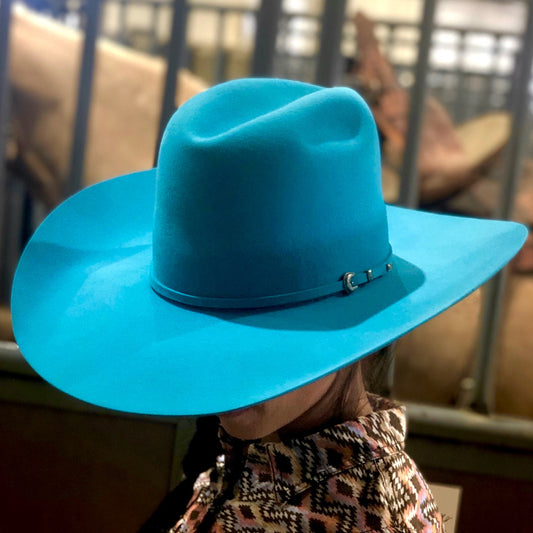 Youth woman turquoise hat in ranch setting