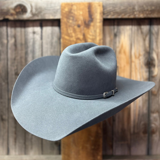 Gray cowboy hat on a wooden post with a rustic wooden background