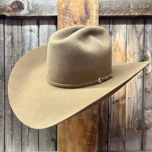 Beige cowboy hat with a band against a wooden background