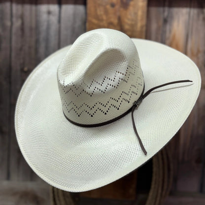 White cowboy hat with a black band on a wooden surface