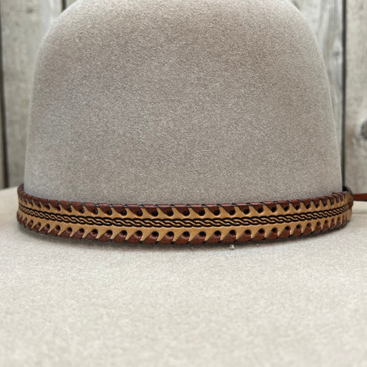 Close-up of a beige headrest with a decorative brown pattern on a wooden surface