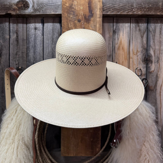 Beige straw hat with black band on a wooden background