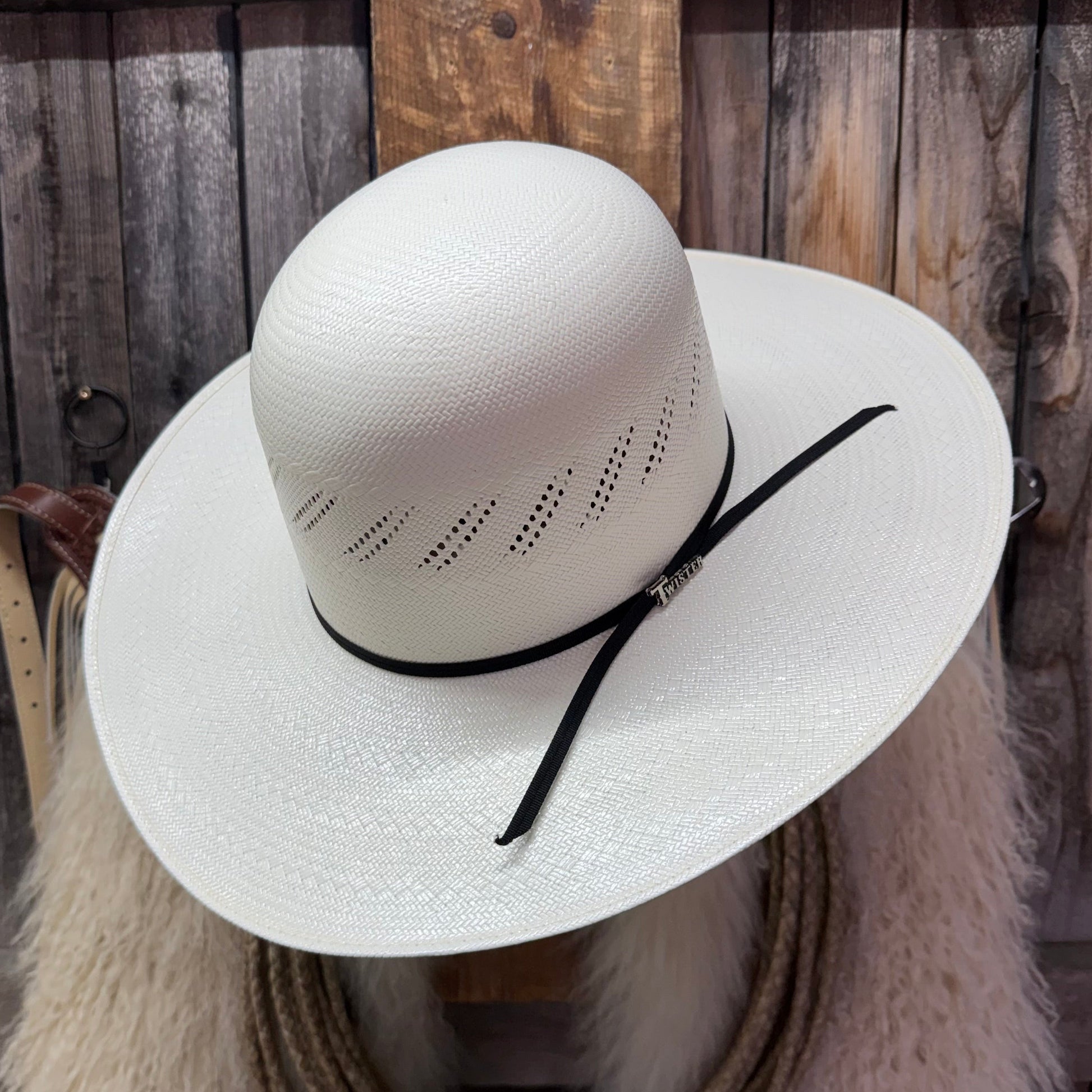 White straw hat with a black band on a wooden background