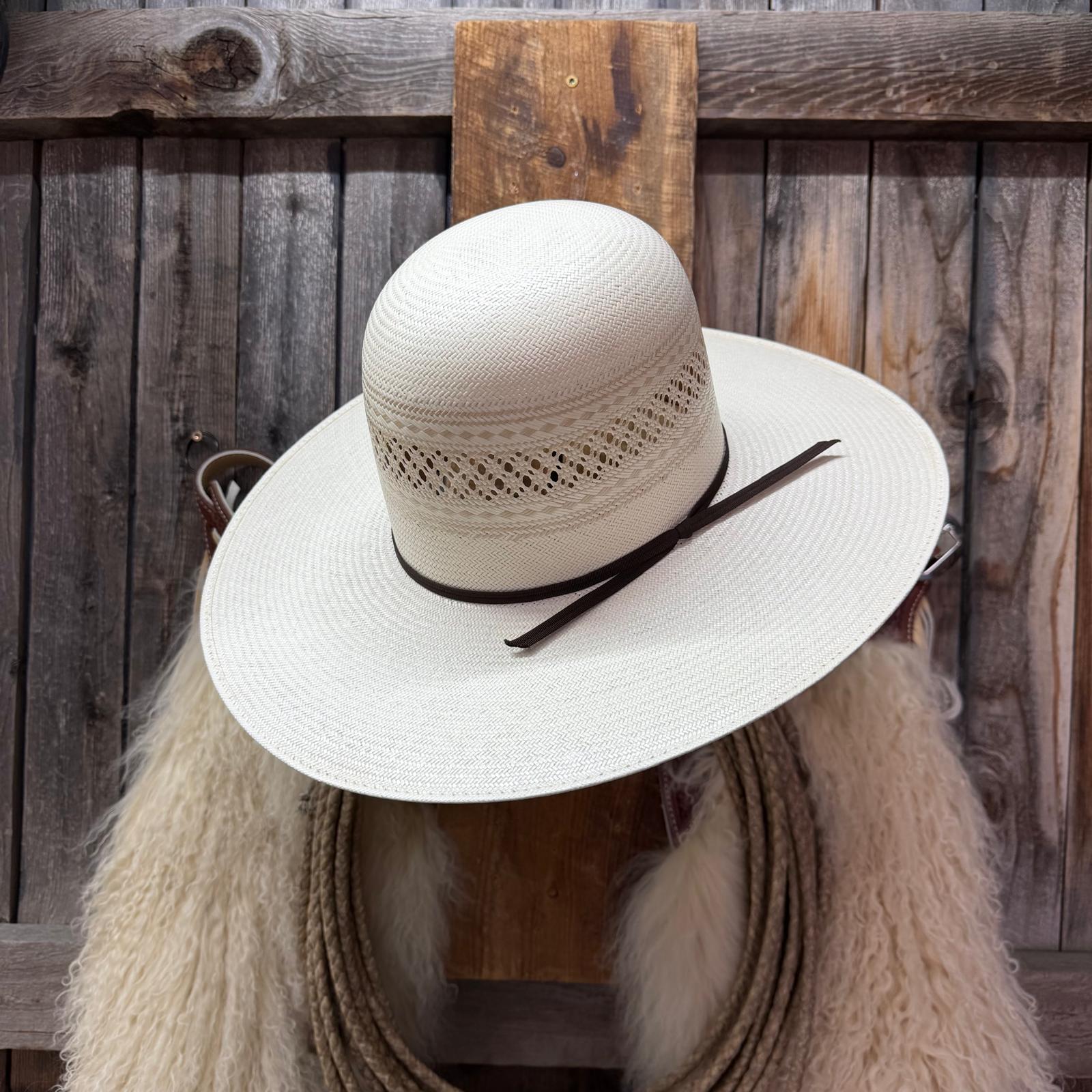 White straw hat with a black band on a wooden fence background