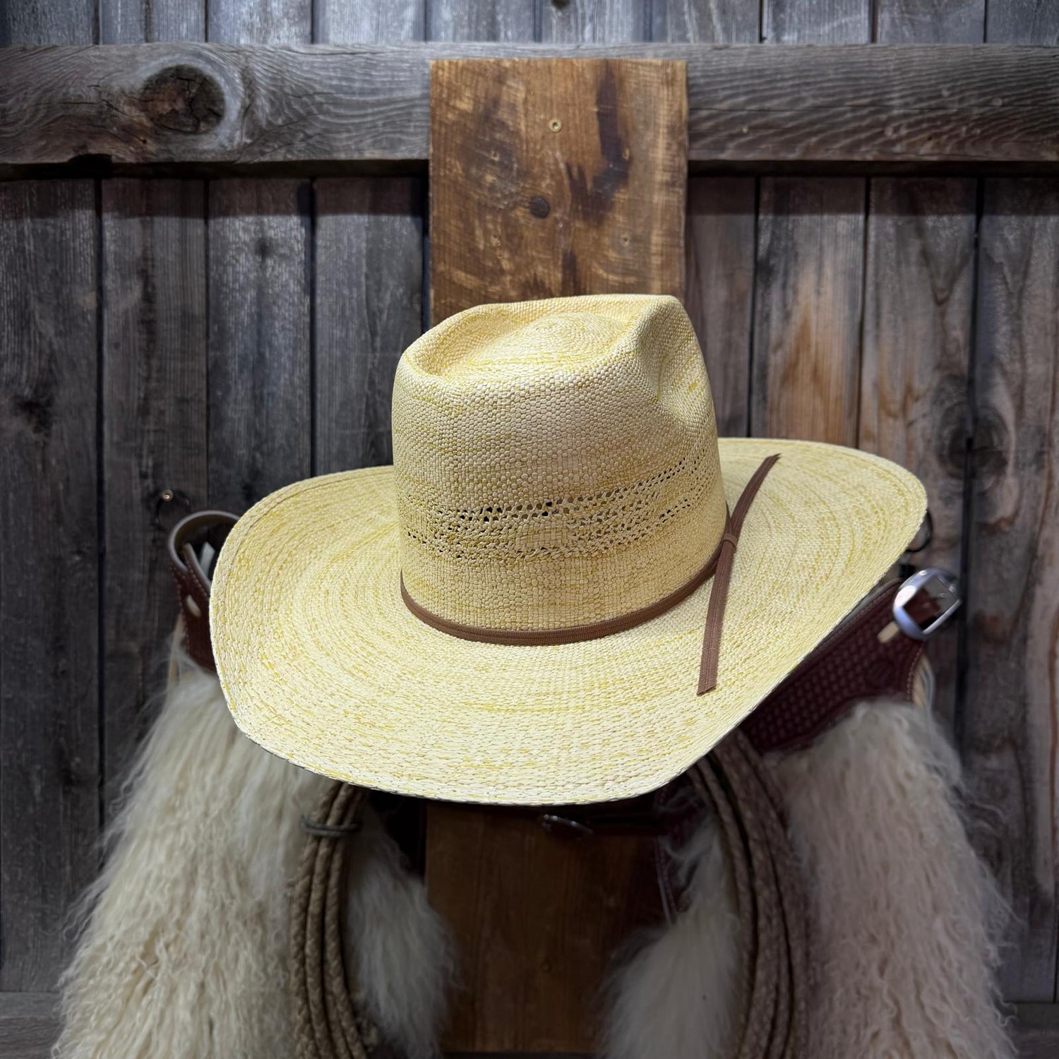Toasted colored Straw cowboy hat with brown ribbon around the bottom  