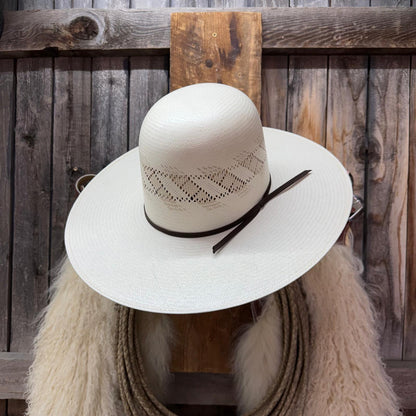 White straw hat with lace details on a wooden background