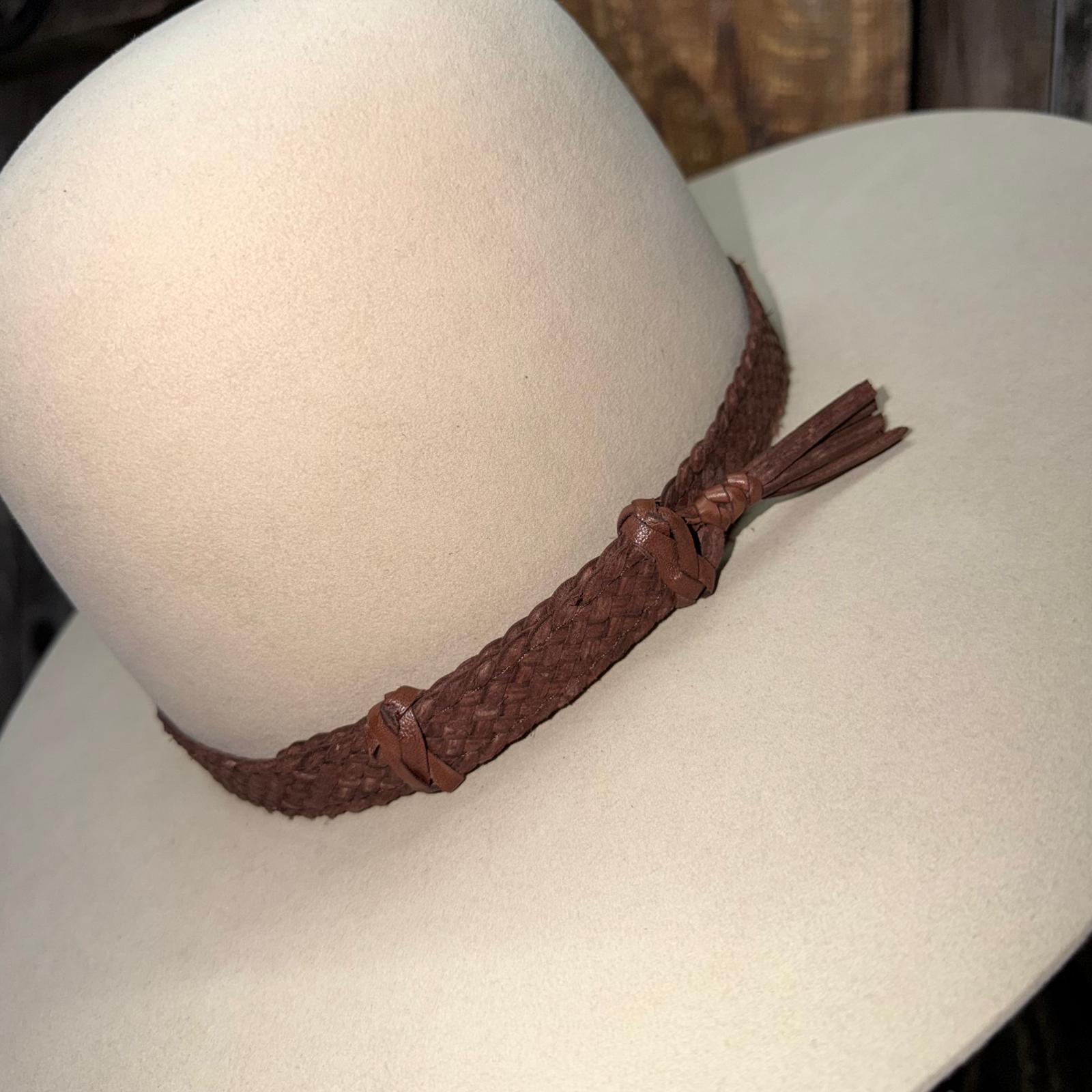 Brown braided leather belt on a white mannequin head